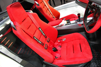 真っ赤なスポーツシート。リアシートは省かれ荷物スペースになっている。
    