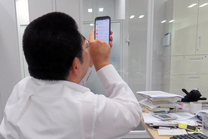 プルプルしながら「新着物件アリ」のメールをひらくwebCGほった（再現図）。この写真を撮影して決意した。今度こそデスクの上を整理しよう。