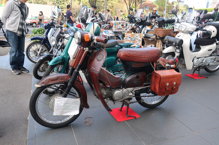 茶色の「カブ」はフルレザーカバー付き。なんとオーナーによる手縫いのお手製品で、ほとんどのパーツは牛のヌメ革でできている。ベース車は「スーパーカブ90デラックス」（2005年）だ。