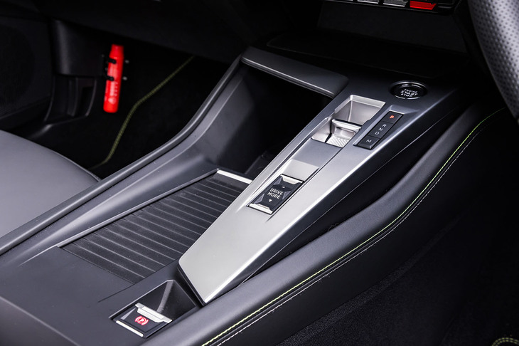 トグルスイッチ型の小さなシフトセレクターはプジョー車でおなじみのデザイン。その後方に走行モードの切り替えとサイドブレーキの操作スイッチが置かれる。