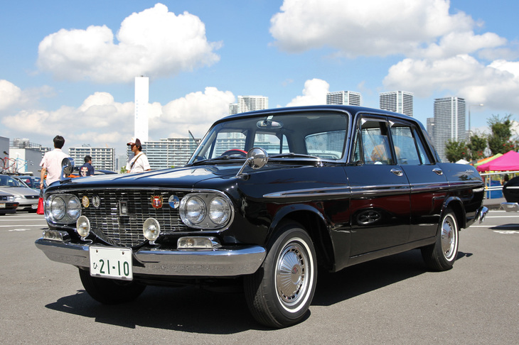 ホイールキャップを含めノーマルの姿が保たれた「トヨペット・クラウン デラックス」。1962年にデビューした型式名RS41こと2代目クラウンの最初期型。フロントグリルのデザインは、TOYOTAの“T”がモチーフという。