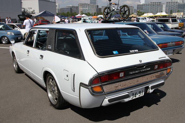 後ろからの眺めも個性的な「トヨタ・クラウン カスタム」。フューエルリッドの後方にあるエアアウトレットも妙にスポーティーな印象を与える。カーゴルームには後ろ向きの折り畳み式サードシートが備わり、乗車定員は7／8名。