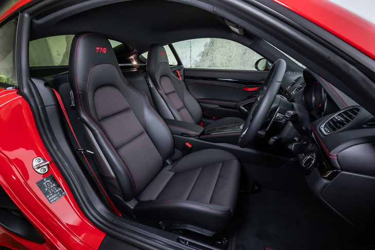 ヘッドレストに「718」の数字が刺しゅうされた2ウェイ電動スポーツシートが標準装備となる「718ケイマンT」。今回の試乗車は、ガーズレッドのアクセントカラーを用いた「718Tインテリアパッケージ」が選択されていた。
