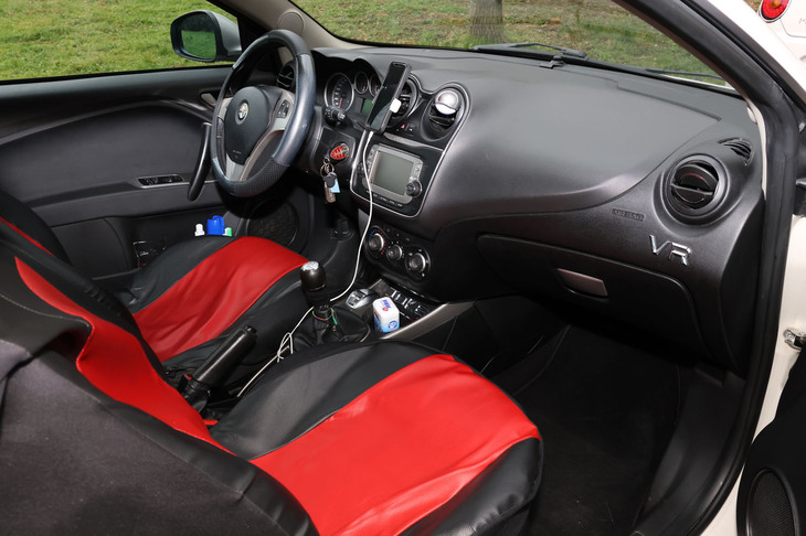 市販のシートカバーが「ミト」へのいたわりを感じさせる。ダッシュボードの右端に貼った「VR」は彼のイニシャル。