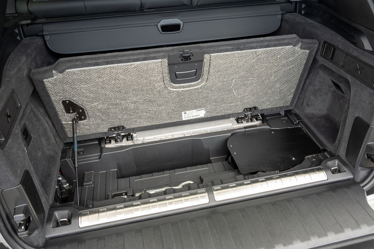 ラゲッジアンダースペースのカバーはダンパー付き。右の手作り感あふれる金属の板の下にはデータロガーのような装置が収められていた。