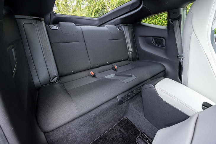 後席は2人掛け。センターには小物が置けるトレーが配置されている。左右Cピラーの内側に大きな張真り出しがあるため、大人が真っすぐ前を向いて座ることは難しい。