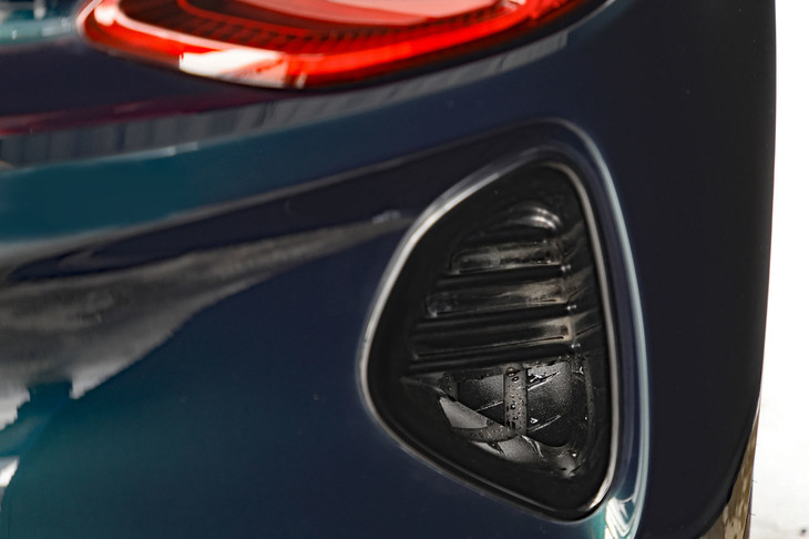 エアダクトの奥にのぞくタイヤのトレッドパターンに注目。「エミーラ」の空力デバイスはすべて機能を伴うもので、走行時に空気を整流するほか、201km/h走行時には55kgのダウンフォースを発生するという。