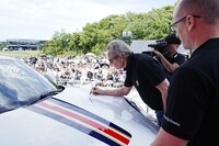 「911ダカール」のボンネットにサインするジャッキー・イクス氏。