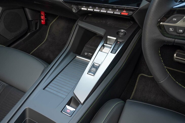 背丈を抑えたシフトセレクターはつまんで操作するスイッチ式。シャッターの下にカップホルダーが備わっている。