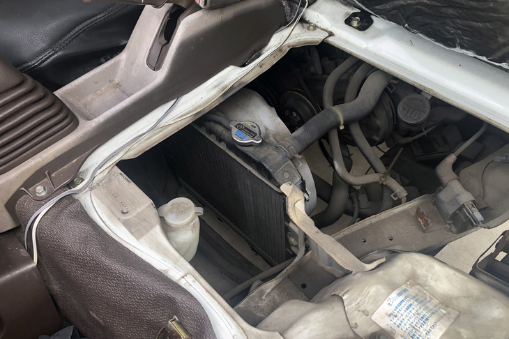 シートを持ち上げると、その下にラジエーターが。エンジンはさらにその後ろなので、キャブオーバーの軽トラは間違いなくミドシップだ！ つまりオレはミドシップ後輪駆動3台持ち！