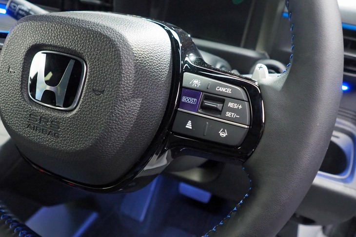 ブルーのステッチが入る2本スポークデザインの本革巻きステアリングホイール。右スポークのスイッチパネルには、「BOOST」モードの選択ボタンが備わる。