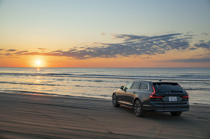 日本海に沈む夕日と「V90 B6 AWDインスクリプション」。取材当日における石川・千里浜なぎさドライブウェイ付近の日没時間は、16時47分と発表されていた。燃料満タンで東京を出発し、一度も給油することなく同地まで走り切ることができた。