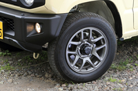 80偏平（！）の肉厚なタイヤも「ジムニー」の特徴。タイヤ交換時に手が差し入れやすいよう、ホイールアーチのデザインは半円形から台形に変更された。