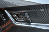 ドアトリムにもカーボンを使用。インナードアハンドルはシンプルなレザーストラップとなる。