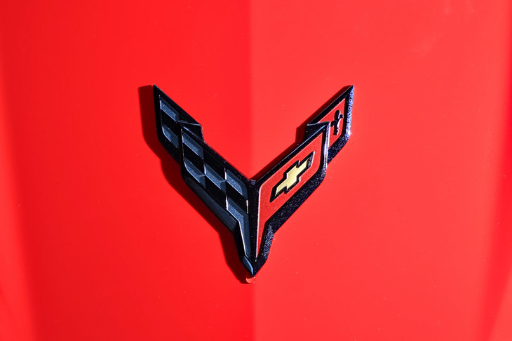 チェッカードフラッグとシボレーの“ボウタイ”がデザインされた、コルベット伝統のエンブレム。世代によって意匠が異なり、C8では黒い縁取りと狭い夾角（きょうかく）が目を引くものとなった。
