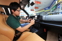 カーオーディオをチェックする奥山さん。シート下のウーファーやグラブボックス内のETCなど、入札金額に関わる隠れた装着部品についても別途申告する。