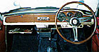 木目パネルに円形メーターを配したベルリーナのインパネ。4段ギアボックスはコラムシフトとフロアシフト（画像）が選べ、後者にはスポーティな3スポークのステアリングホイールが装備された。