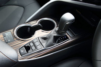 シフトレバーの手前（写真左下）には走行モードのセレクトボタンが備わる。写真は上級グレード「G“レザーパッケージ”」のもので、“タイガーアイ調”の装飾パネルが与えられる。