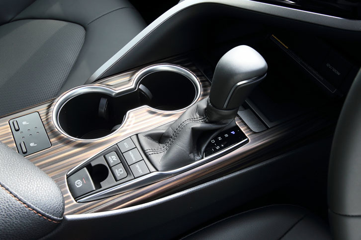 シフトレバーの手前（写真左下）には走行モードのセレクトボタンが備わる。写真は上級グレード「G“レザーパッケージ”」のもので、“タイガーアイ調”の装飾パネルが与えられる。