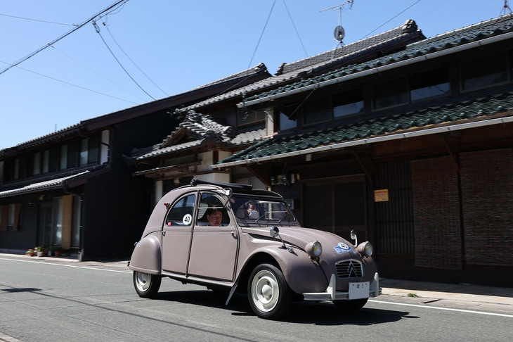 古風な家並みが残る宿場町である大野宿を行く、桜にも似た微妙で味わい深い色の「シトロエン2CV」。