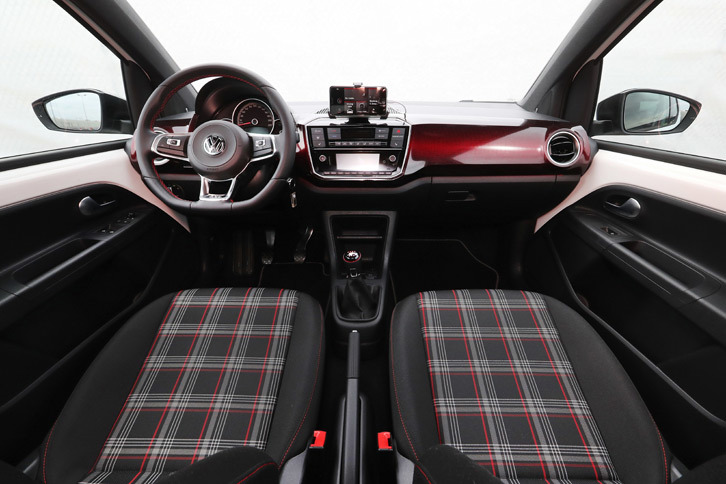 “ピクセルレッド”（四角い赤のドット柄）のグラデーションが施された装飾パネルや、タータンチェックのシート地が目を引くインテリア。内装色は黒が基調で、ダッシュボードやドアパネルだけでなく、ルーフやピラーの内張りも同色で統一されている。