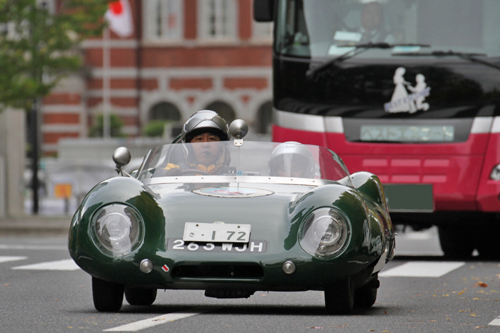 後ろから塗り壁のような大型バスに迫られる（？）1956年「ロータス11」。コドライバーの坊やは、10歳にしてすでに5年のキャリアを持つベテランだ。