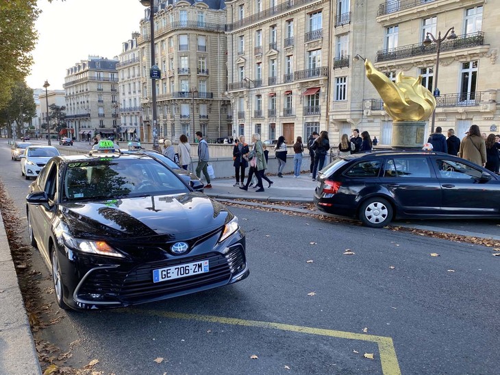 「自由の炎」前で。気がつけば前回筆者がパリモーターショーを訪れた4年前よりも、タクシーの「トヨタ比率」がさらに高い。背景には、9500台を展開する欧州最大のタクシー会社G7が、すでに保有車両のうち5500台を環境対策車にしていることもある。