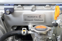 タイミングチェーンカバーの正面には、エンジンを組んだ工員の名が書かれた、アルミ製のネームプレートが装着される。