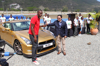 日産ラテンアメリカ＆カリビアン副社長のホセ・ロマーン氏から、「GT-R」のキーを受け取るボルト選手。