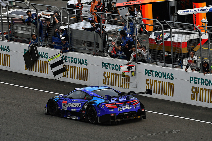 レースを制したジェンソン・バトンを、チームメイトが歓喜の声とともに迎える。