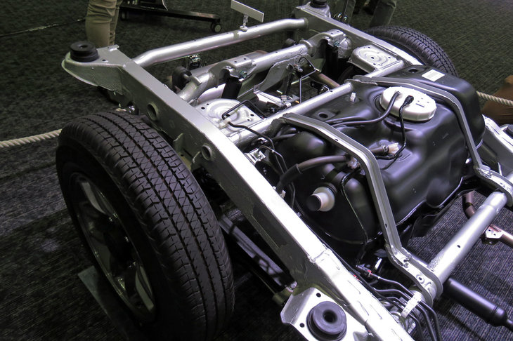 ラダーフレームの後部とガソリンタンク。新型「ジムニー／ジムニーシエラ」には、タテ方向はやわらかく、ヨコ方向には固いボディーマウントが採用されており、乗り心地と走行安定性の両立が図られている。