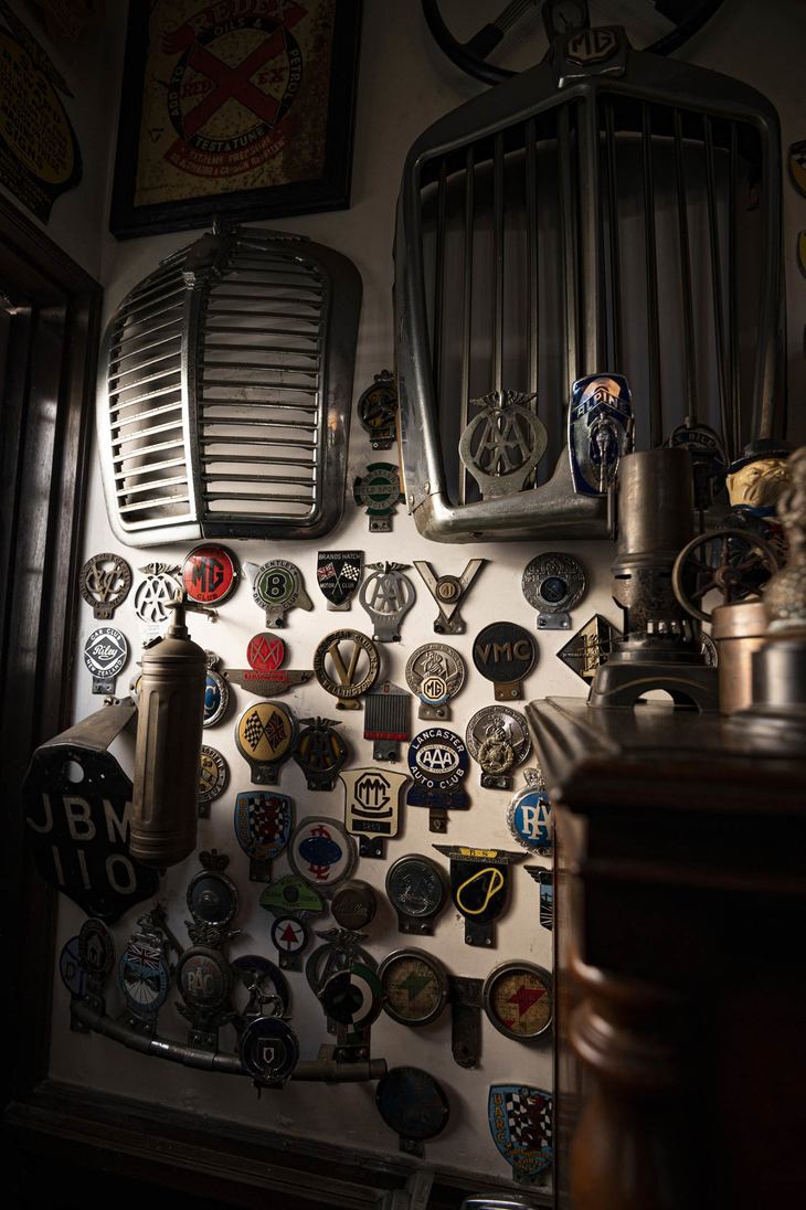 壁にはラジエーターグリルなどの自動車パーツ、さまざまなバッジがディスプレイされている。