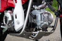 エンジンガードやアンダーガードに囲まれた空冷単気筒エンジン。124ccの排気量から最高出力8.8PS、最大トルク11N・mを発生する。