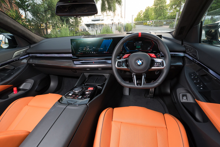 ダッシュボードは大きなカーボンパネルが左右を横断する豪勢な仕立て。この試乗車のインテリアカラーはキャラミオレンジとブラックのコンビネーション。