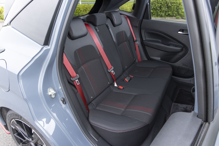 リアにはRECAROシートは装着できないが、赤いシートベルトなどで前席と同じ世界観が貫かれている。後席空間の広さは「ノート」シリーズ全体に共通する美点のひとつだ。
