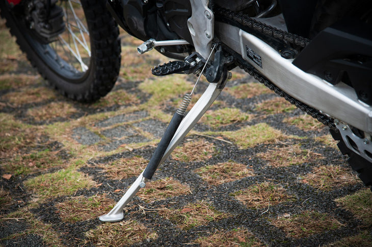 強度と軽さを重視したアルミニウム製サイドスタンド。荒れた路面の走行でも邪魔にならないよう、レイアウトも配慮したものとなっている。
