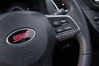 赤いステッチやSTIのロゴが施されたステアリングホイール。右側のスポークには走行モード切り替えシステム「SIドライブ」のスイッチが備わる。
    