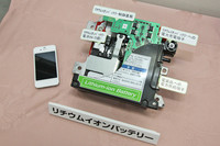 コンパクトなリチウムイオンバッテリー。スマートフォン（iPhone：写真左）と比べると、そのサイズがおわかりいただけるだろうか。