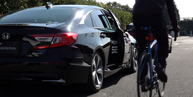 「降車時車両接近警報」のデモンストレーションの様子。自動車だけでなく、自転車なども検知する。