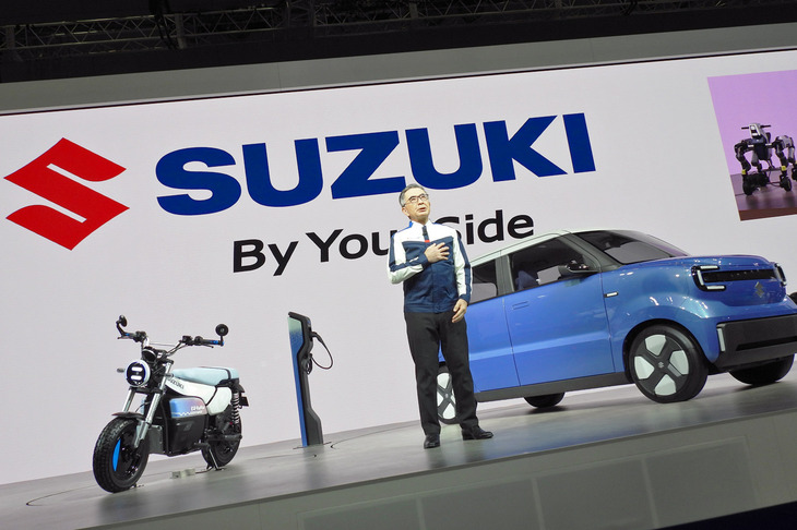 スズキの鈴木俊宏社長と、コンセプトモデルの「Vision e-Sky（ビジョンeスカイ）」（写真向かって右）と「e-VanVan（eバンバン）」（同左）。