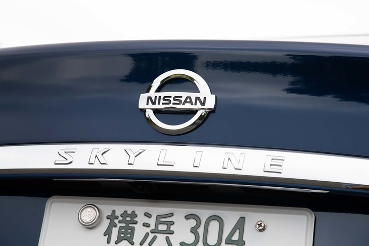 フロント、リア（写真）ともインフィニティエンブレムを捨てて日産エンブレムに。ガーニッシュ内には「SKYLINE」ロゴも加えられた。