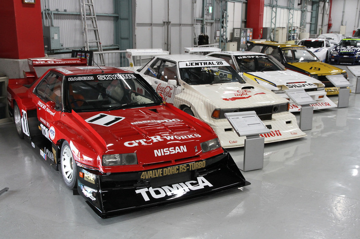 手前から、1982年に長谷見昌弘が駆った「トミカ スカイライン ターボ」、1984年に柳田春人がドライブした「コカコーラ キヤノン ブルーバード ターボ」、そして1983年に星野一義が駆った「ニチラ インパル シルビア ターボ」のスーパーシルエット3兄弟。いずれもパイプフレームで組んだシャシーに2.1リッター直4 DOHC 16バルブターボのLZ20B型エンジンを搭載、各モデルに似せたボディーをかぶせたマシンである。3台の奥に見えるのは、初代「マーチ」をスーパーシルエット風に仕立てたイメージモデルの「マーチ スーパーシルエット」。