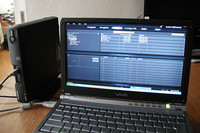 付属するリビングキット（左）にナビの頭脳「ブレインユニット」を入れると様々なことができる。TVとつなげばスマートループ情報のダウンロード、アップロードができるし、PCとつなげばミュージックサーバーの音楽データを追加・削除したり地点情報の編集ができる。
