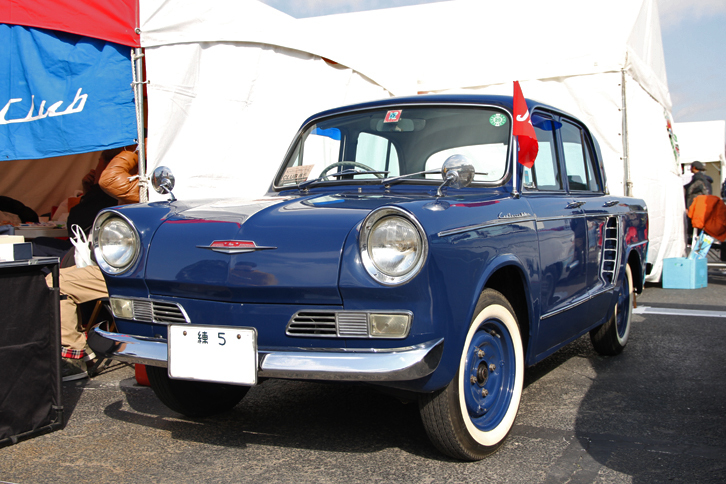 1962年「日野コンテッサ900デラックス」。「ルノー4CV」のライセンス生産から得たノウハウをベースに、61年に誕生した日野初のオリジナル乗用車がコンテッサ900。「練5」のシングルナンバーを付けたこの希少な初期型は、日野コンテッサクラブのスタンドに飾られていた。