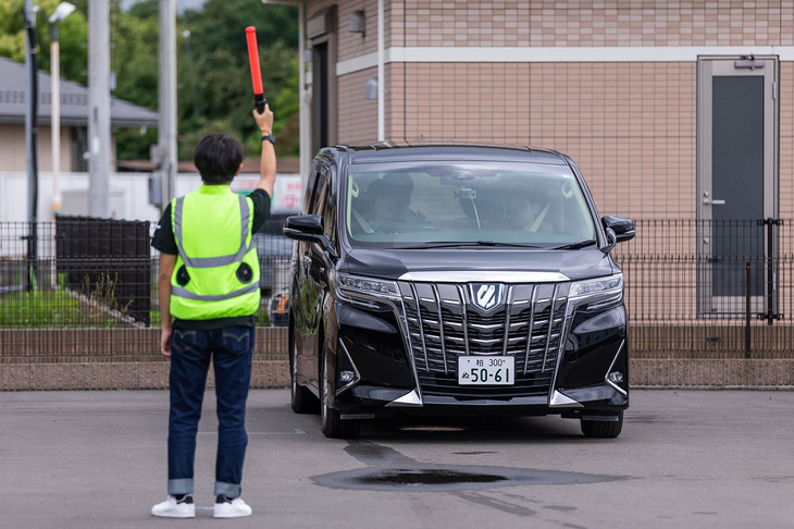 「アルファード」で行われた自動運転のデモ走行では、交通指導員役の指示に車両が従うかなどもテスト。交通指導員役が「止まれ」という身ぶりをすると、自動運転システムがそれを感知して車両はきちんと停止した。