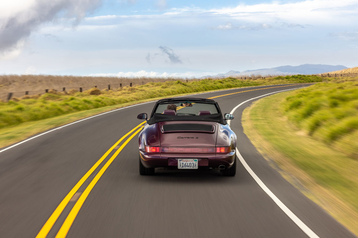 ハワイ島のワインディングロードを行く1992年の964型「911カレラ2カブリオレ」。964型は911の3世代目にあたるモデルで、まず1989年に4WDモデルの「カレラ4」がデビューし、続く1990年にRRのカレラ2が発表された。