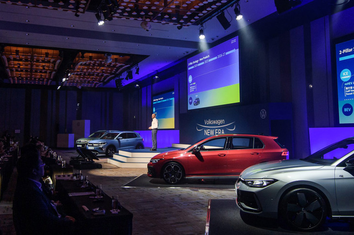 2024年後半に導入するモデルと導入プランを発表したフォルクスワーゲン ジャパンのブランドディレクター、アンドレア・カルカーニ氏。ステージ上には新型車が4台並んだ。