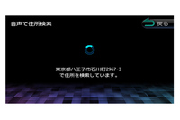 上のメニューから「音声住所」を押すと「VOIPUT」というスマートフォンの音声入力アプリが働き、スマートフォンに向かって住所を発声すると、このようにナビ側で該当地点を探し出してくれる。
    
    