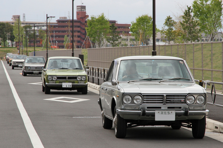 生まれ故郷である村山工場跡地周辺を連なって走る、7台の初代「ローレル」。