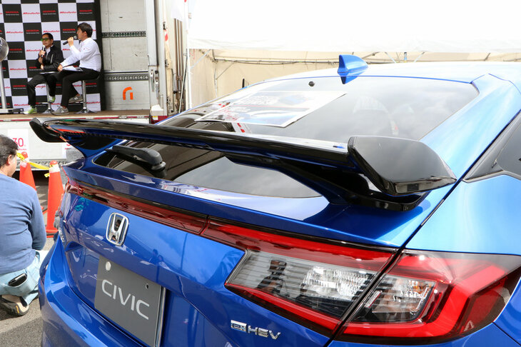ステージ前では、現在開発中の現行「ホンダ・シビック」用テールゲートスポイラー（ウイングタイプ）の試作品が初披露された。ホンダ鷹栖テストコースを走り込んで磨いた空力性能が自慢だという。2024年内の発売を予定しているとのこと。
